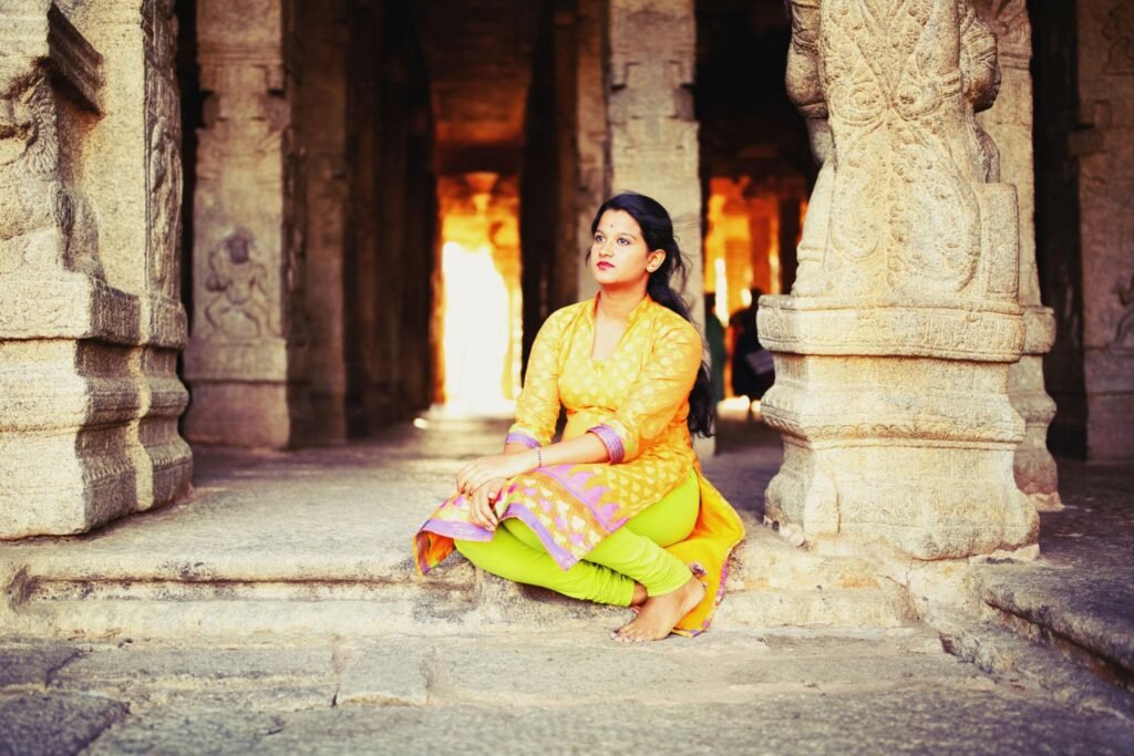 Young adult reflecting peacefully inside an Indian temple, exploring spirituality, mindfulness, and mental wellness in the digital age.
